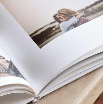 Otvoren fotoalbum sa fotografijom para u zagrljaju