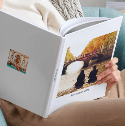 Osoba drži otvoren fotoalbum Amsterdam 2018 sa fotografijom para na mostu
